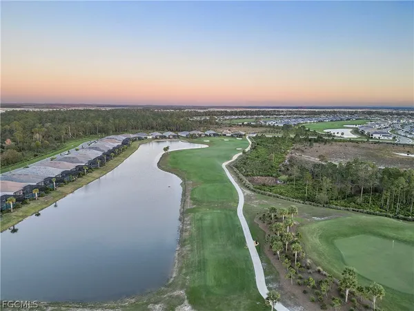 an aerial view of a house with a yard and lake view