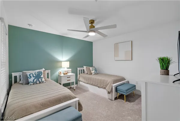 a bedroom with two beds and a potted plant