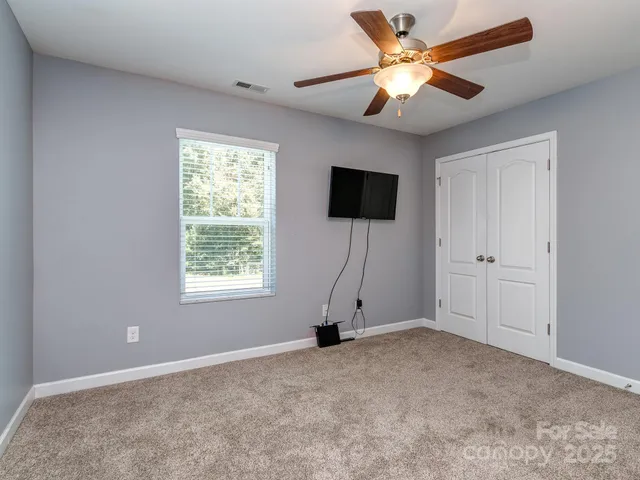a view of an empty room with furniture and a window