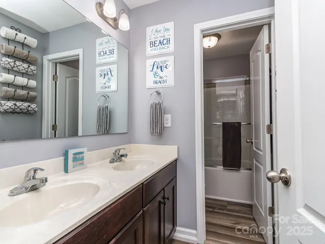 a bedroom with a bed painting on wall and a window