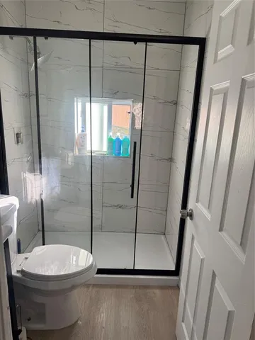 a bathroom with a toilet and a shower