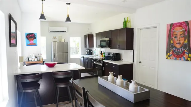a kitchen with a dining table cabinets and appliances