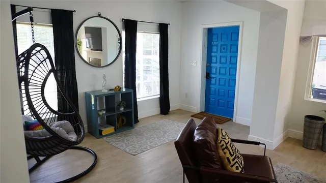a living room with furniture a mirror and wooden floor