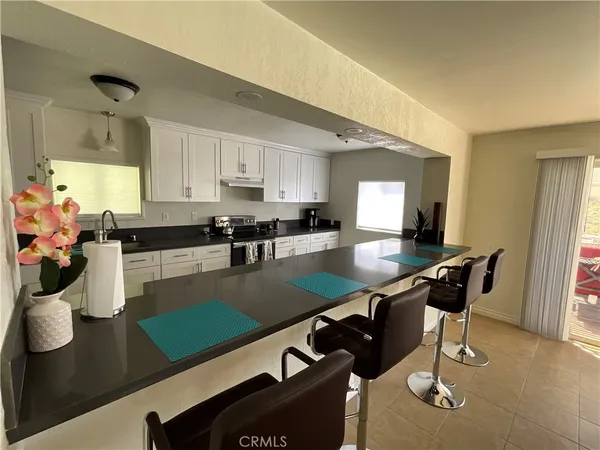 a kitchen with a table chairs and white cabinets