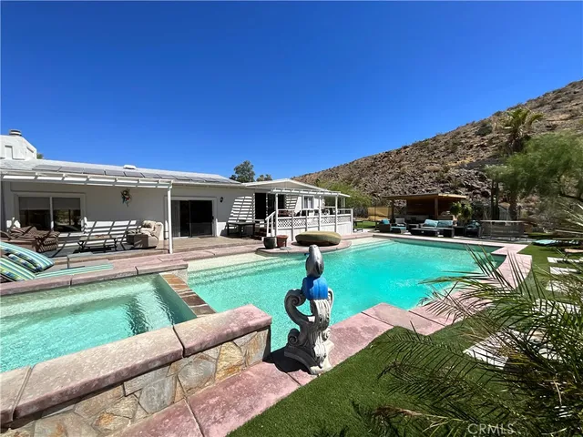 a front view of a house with swimming pool garden and patio