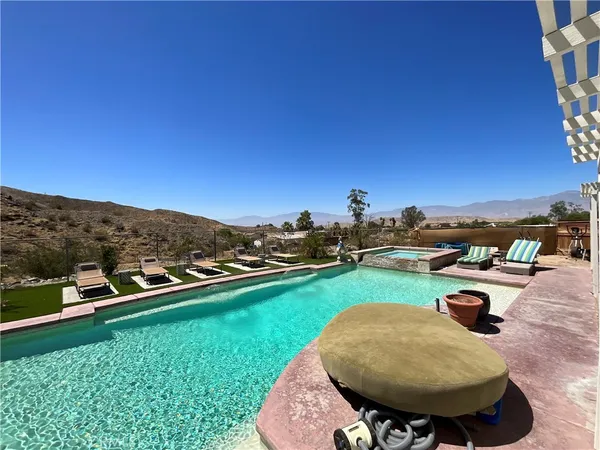 a view of a swimming pool and lounge chairs