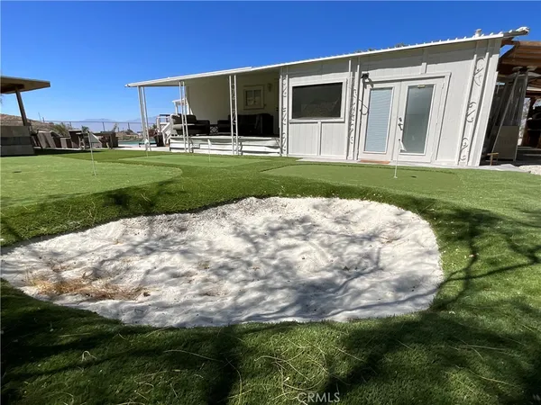 a view of a backyard with plants and large trees