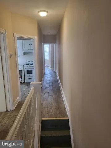 a view of a hallway with wooden floor and staircase