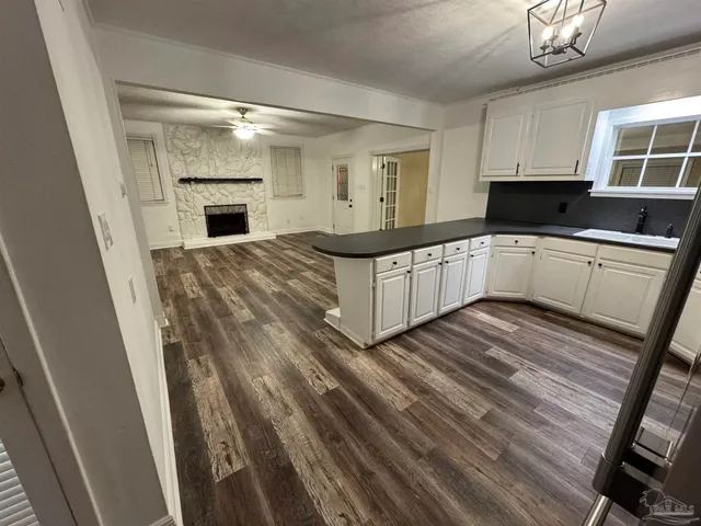 a kitchen with granite countertop a refrigerator and a stove top oven