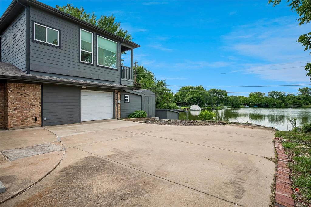2001 Pebblebrook Trail Irving, TX 75060 - Photo 39 of 40 View of side entry garage, attached workshop, and view of lake in the background.