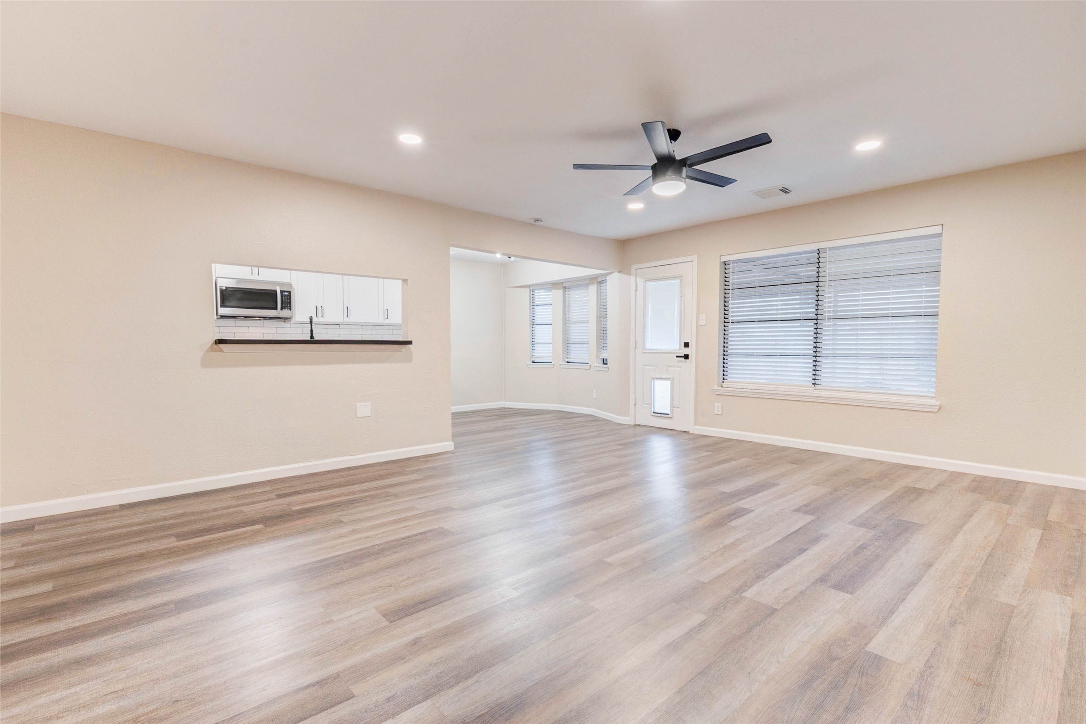 11222 Sagepark Lane Houston, TX 77089 - Photo 18 of 41 an empty room with wooden floor ceiling fan and windows