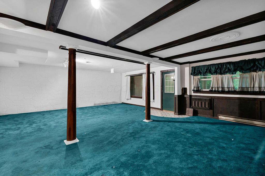 4409 Newton Road Northeast Newark, OH 43055 - Photo 55 of 87 • Green carpet • Ivory painted walls • Decorative ceiling beams • Track lighting • Walks-out to side yard • Built-in bookshelves with cabinets • Open to Billiard’s Area