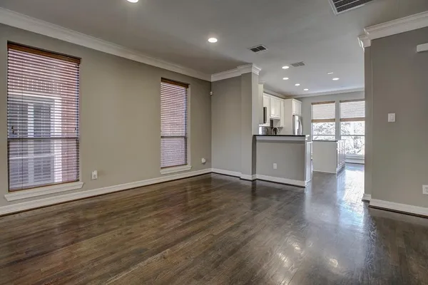 a view of a livingroom with wooden floor and a kitchen space