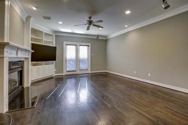 a view of a livingroom with wooden floor and a fireplace