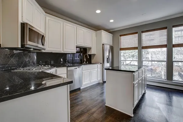 a kitchen with granite countertop white cabinets and white appliances