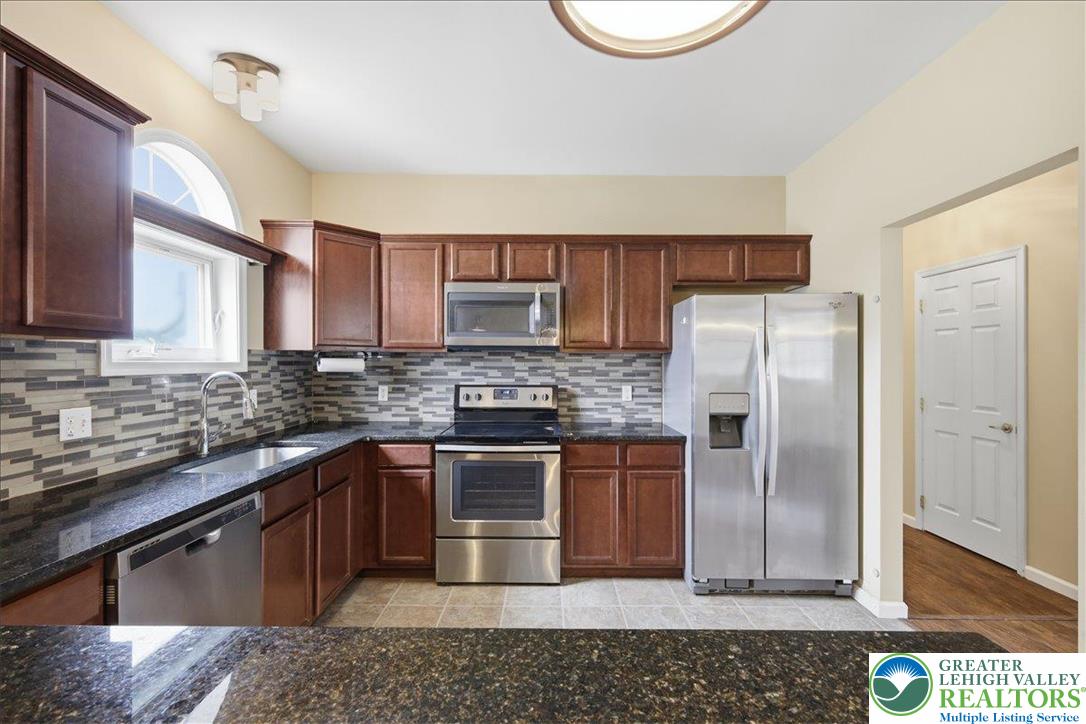 64 Robertson Road Jim Thorpe, PA 18229 - Photo 23 of 54 a kitchen with stainless steel appliances granite countertop a stove a sink dishwasher a refrigerator and cabinets with wooden floor