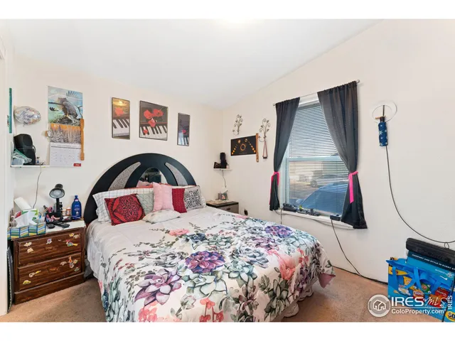 a bedroom with a bed and a painting on the wall