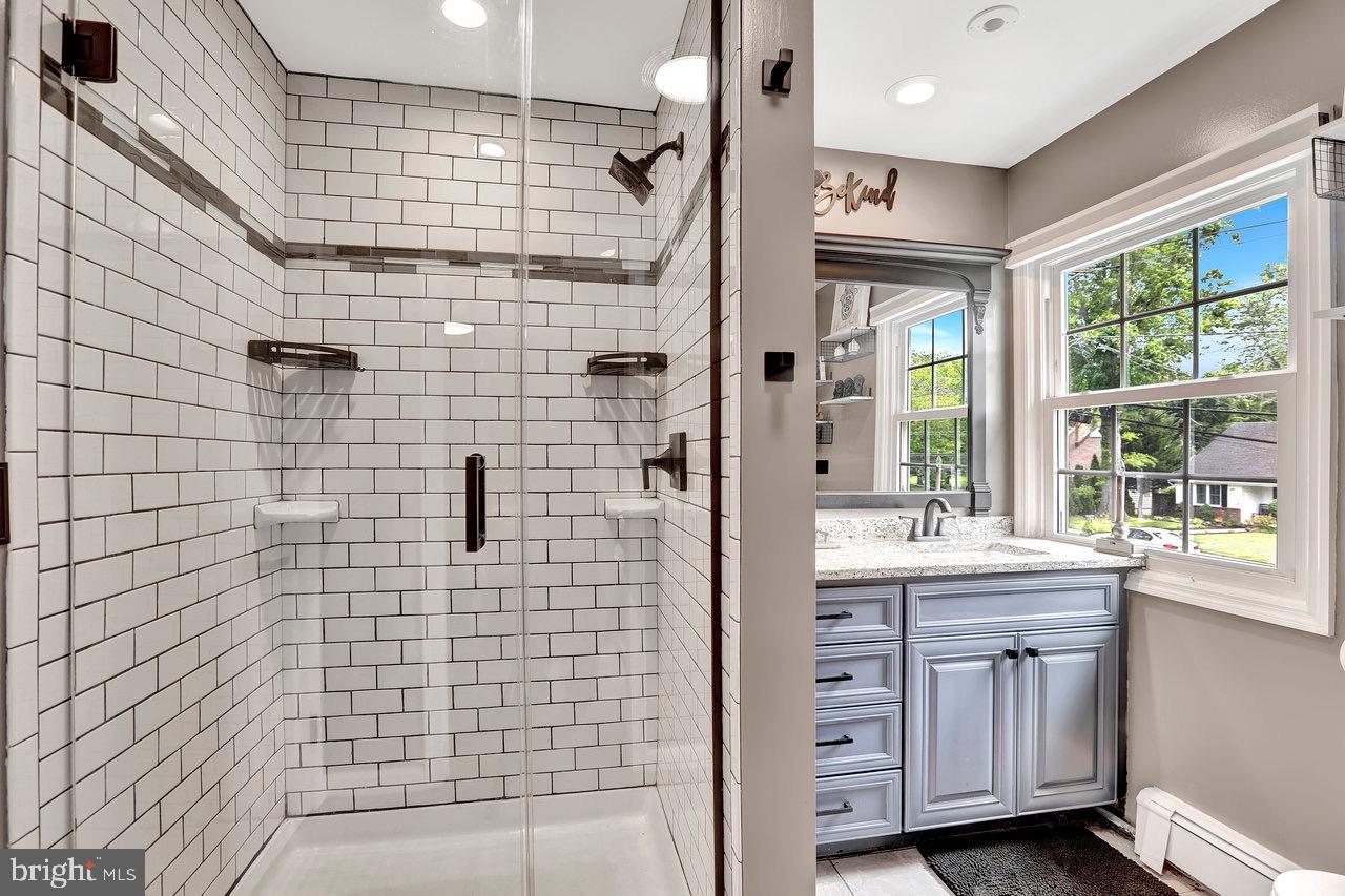 199 Applegate Drive Hamilton, NJ 08690 - Photo 23 of 40 a bathroom with a double vanity sink a large mirror and shower