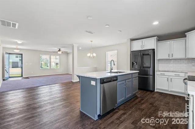 a large kitchen with stainless steel appliances granite countertop a stove and a refrigerator
