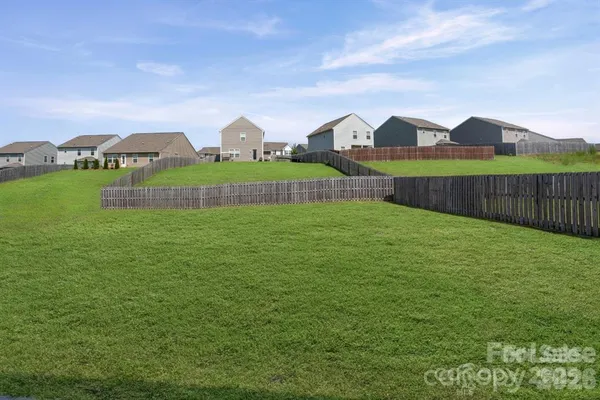 a view of an house with a big yard and potted plants