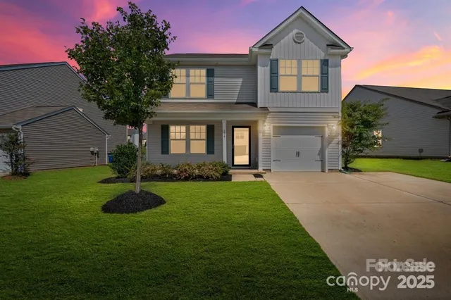 a front view of a house with a garden and yard