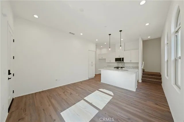 a large kitchen with cabinets a sink a window and stainless steel appliances