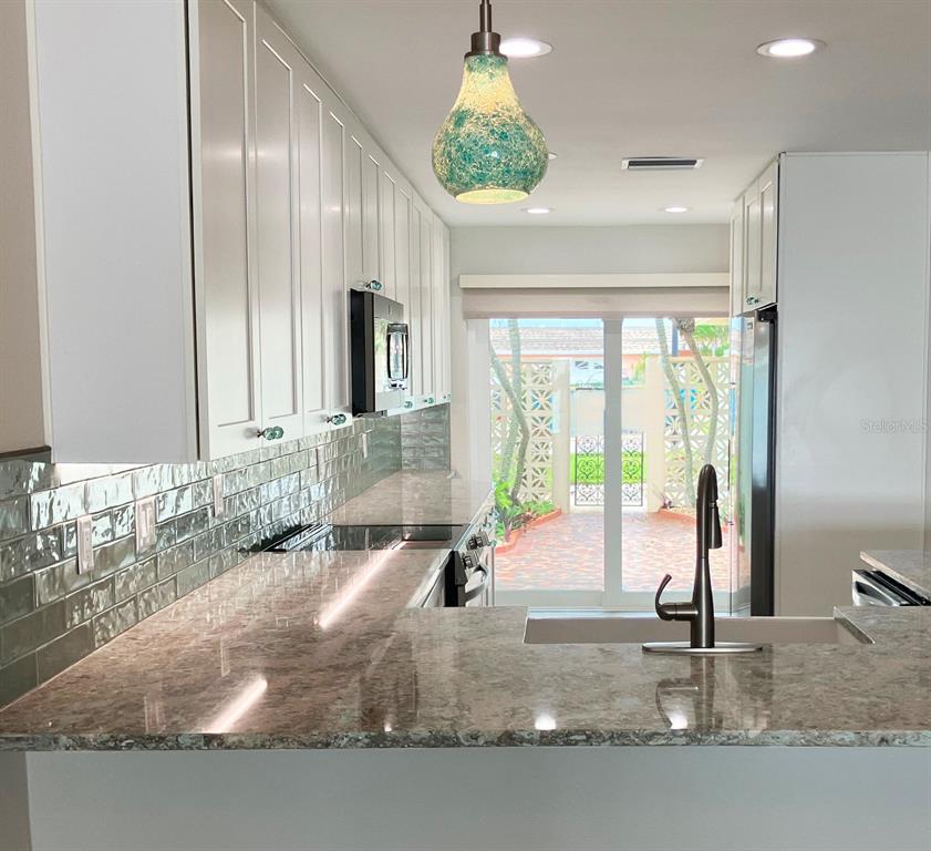 628 Boca Ciega Point Boulevard South St. Petersburg, FL 33708 - Photo 5 of 17 a bathroom with a granite countertop sink and a mirror