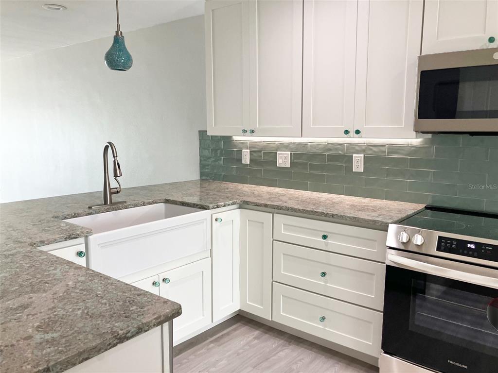 628 Boca Ciega Point Boulevard South St. Petersburg, FL 33708 - Photo 7 of 17 a kitchen with granite countertop a sink and a stove