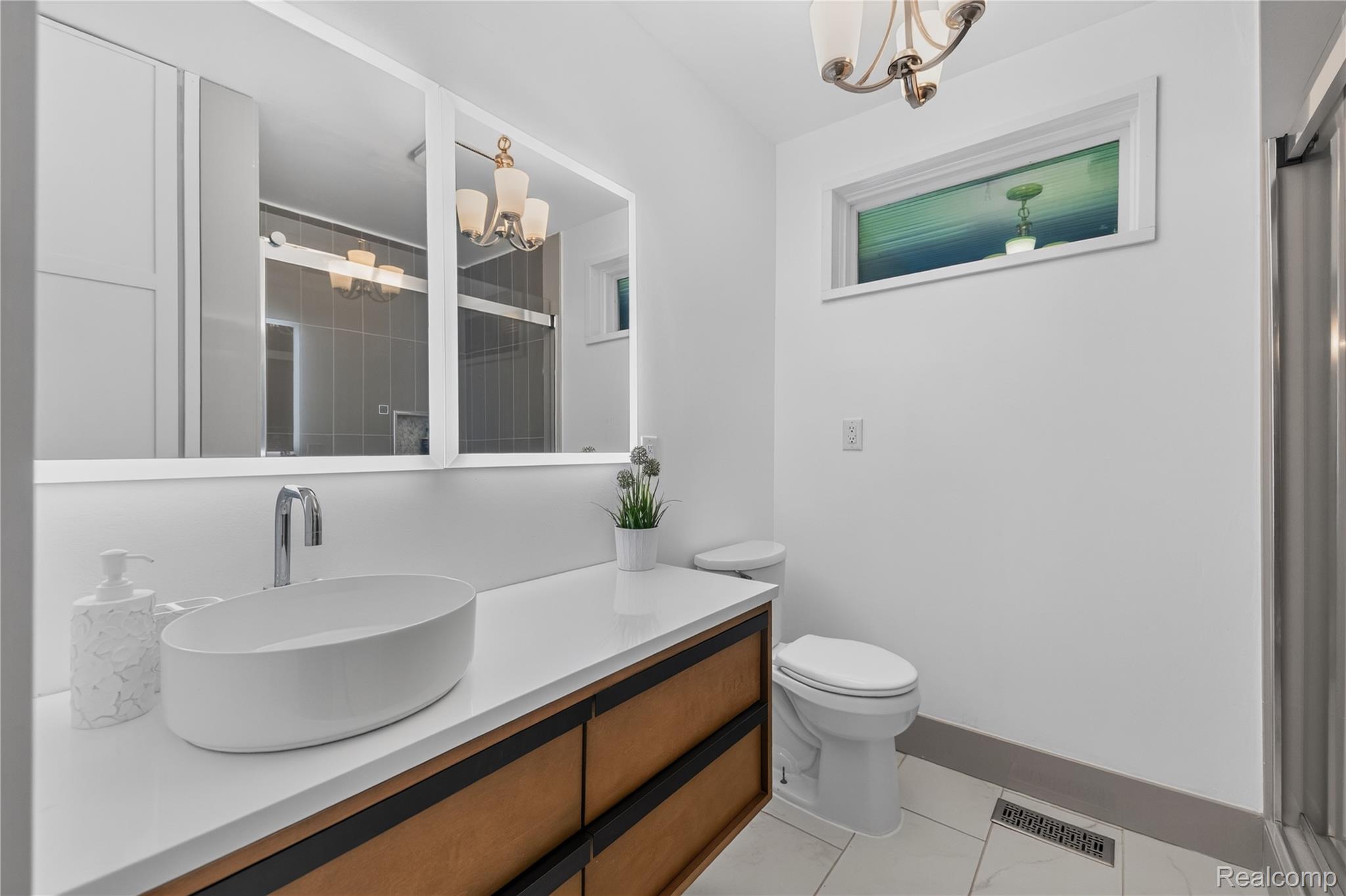4860 Blue Bush Road Monroe, MI 48162 - Photo 29 of 59 Contemporary bathroom vanity featuring a white vessel sink, polished chrome faucet, and integrated backlighting on the mirror