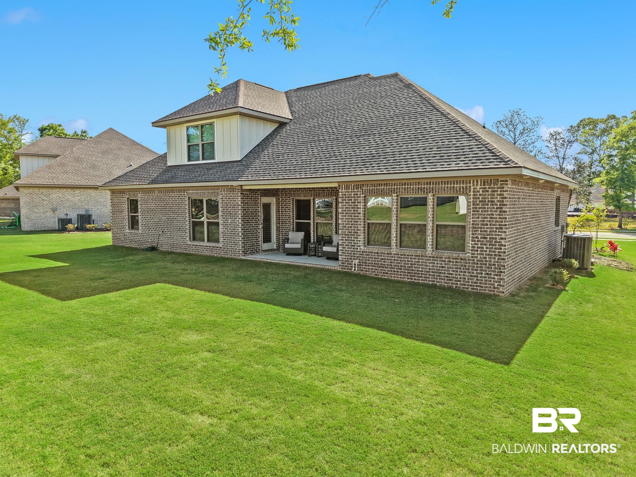 12132 Exbury Way Daphne, AL 36527 - Photo 35 of 47 Back of property featuring a yard, a patio, brick siding, roof with shingles, and board and batten siding