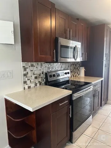 a kitchen with stainless steel appliances a sink stove and cabinets