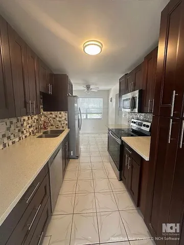 a kitchen with stainless steel appliances a refrigerator sink and microwave