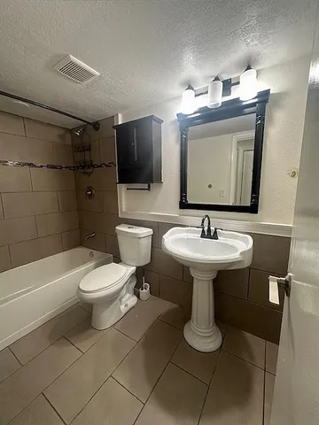 a bathroom with a toilet sink shower and mirror