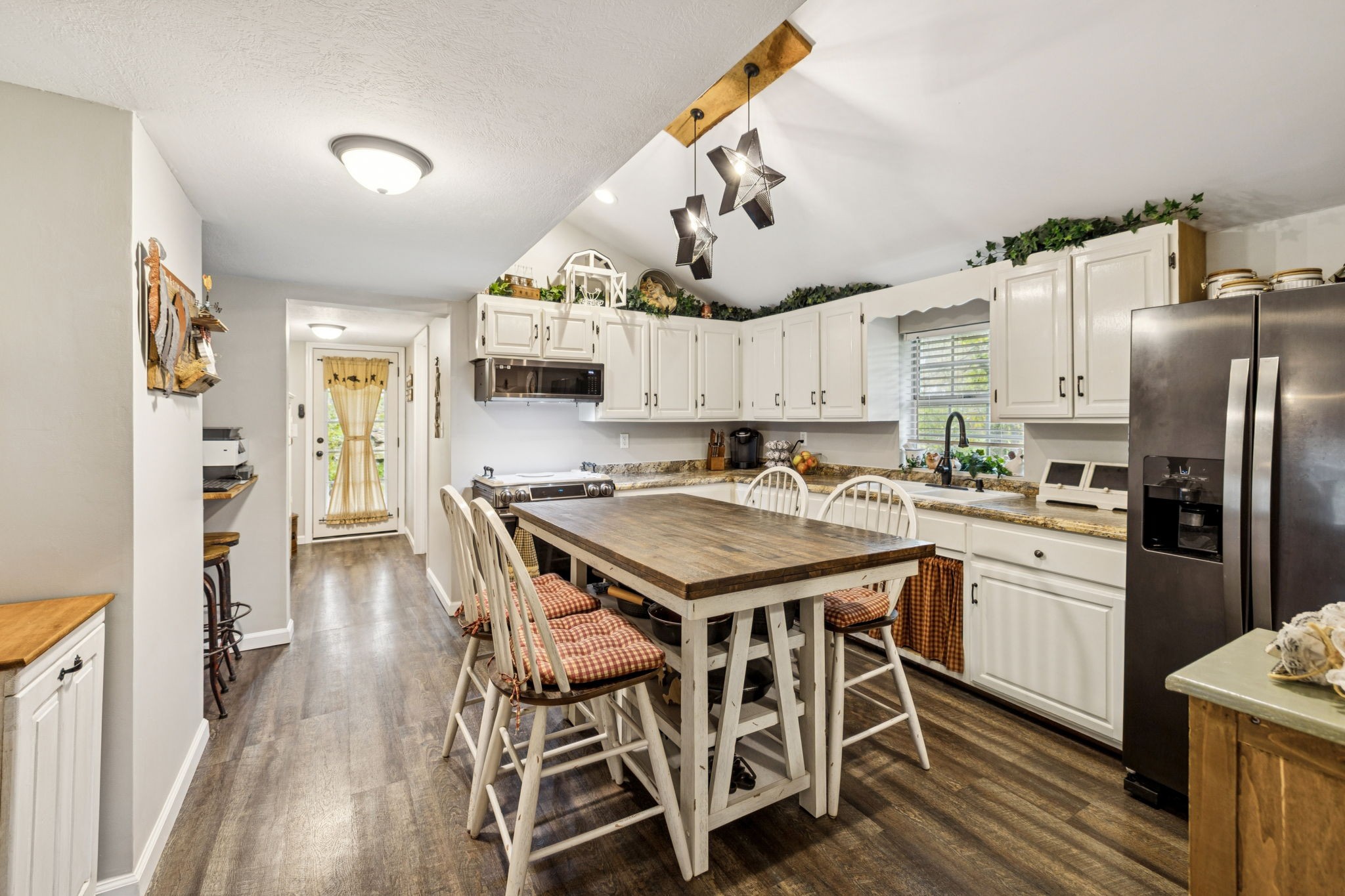 120 Tuttle Lane Bethpage, TN 37022 - Photo 10 of 26 a kitchen with granite countertop a table chairs stainless steel appliances and wooden floor