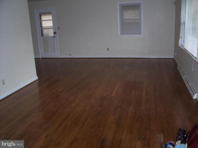 4412 Henderson Road Temple Hills, MD 20748 - Photo 6 of 13 an empty room with wooden floor and windows