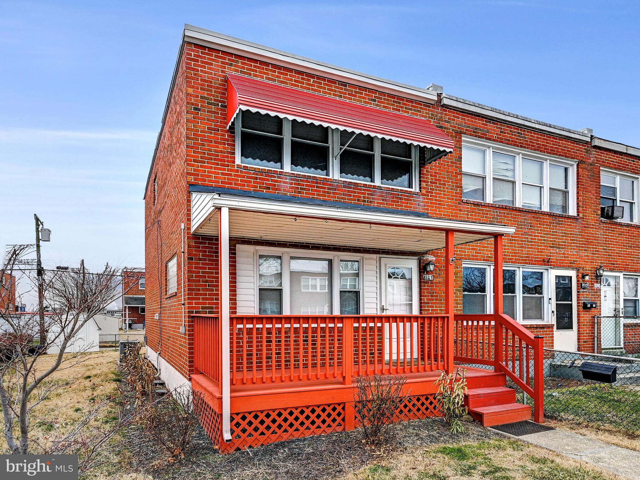 a view of a house with a small yard and wooden fence