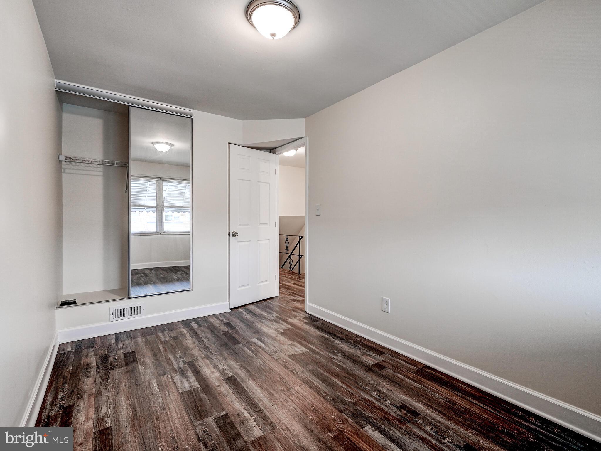 8127 Del Haven Road Dundalk, MD 21222 - Photo 14 of 25 an empty room with wooden floor and windows