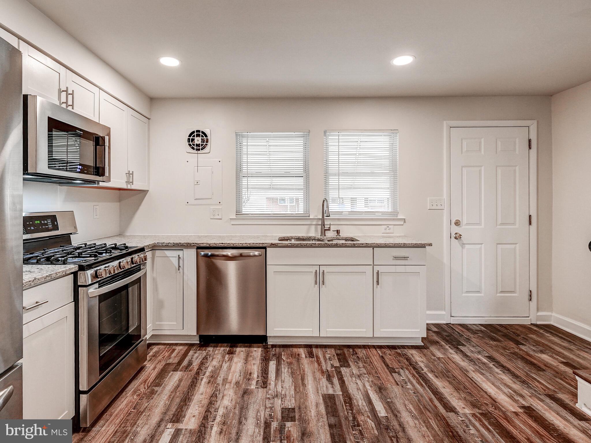 8127 Del Haven Road Dundalk, MD 21222 - Photo 6 of 25 a kitchen with granite countertop a stove top oven sink and cabinets
