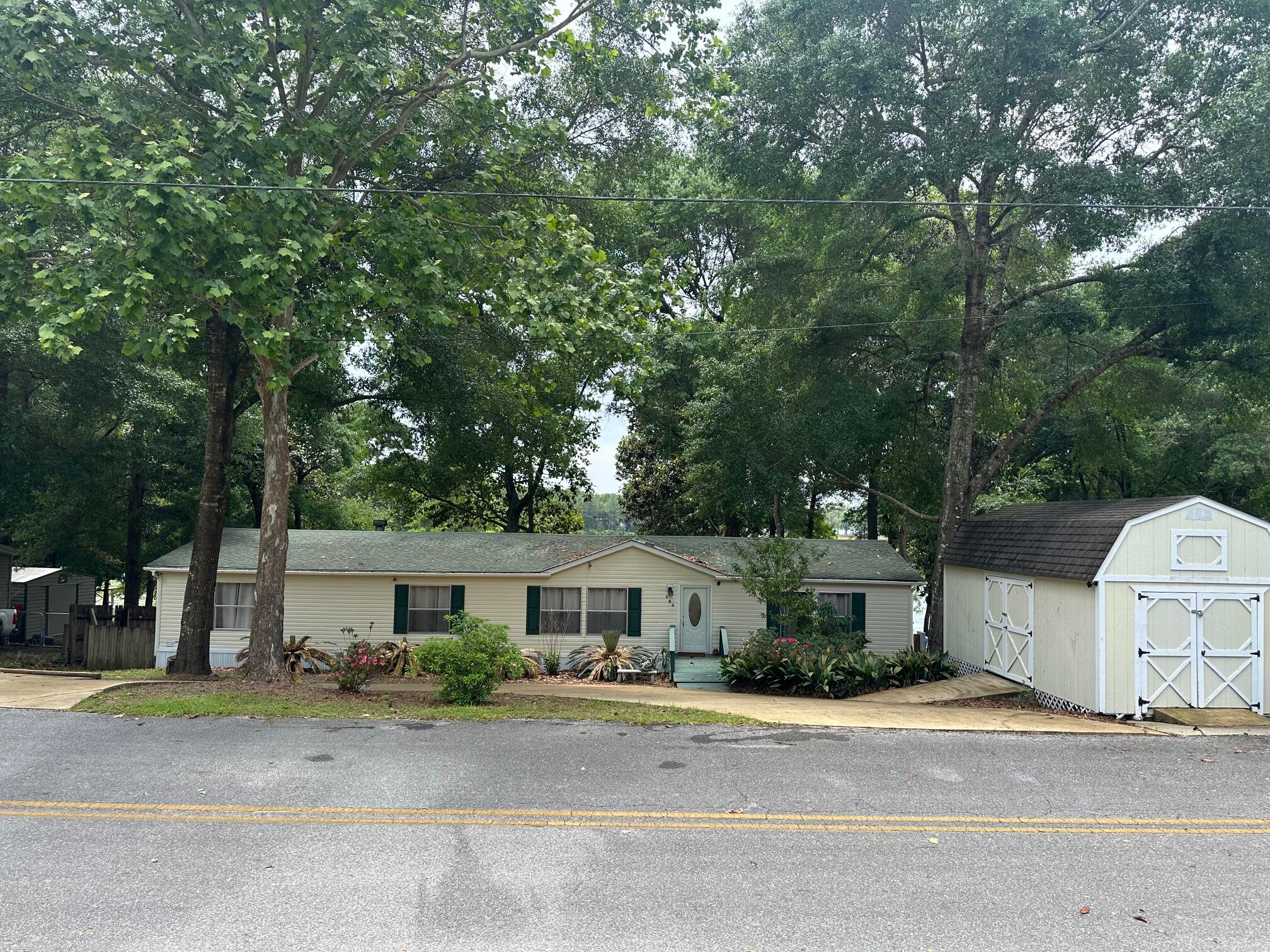 763 Squirrel Road DeFuniak Springs, FL 32433 - Photo 24 of 28 a front view of a house with a garden and tree