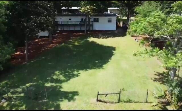 763 Squirrel Road DeFuniak Springs, FL 32433 - Photo 27 of 28 a backyard of a house with a yard and large tree