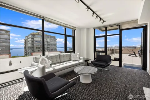 a living room with furniture a large window and dining table