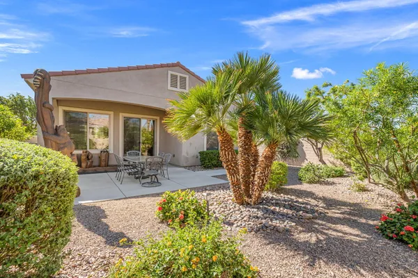 a view of a patio with table and chairs under an umbrella