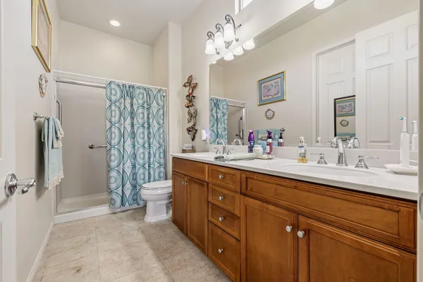 a spacious bathroom with double vanity sink a toilet a shower and a mirror