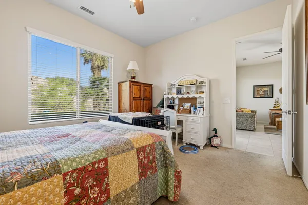a bedroom with a bed and a large window