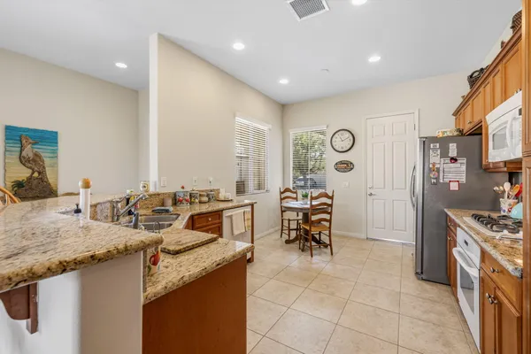 a spacious kitchen with stainless steel appliances granite countertop a sink and cabinets
