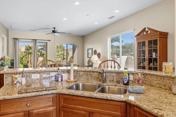 a kitchen with granite countertop a sink and wooden cabinets