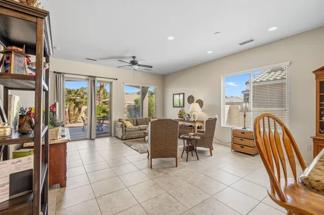 a living room with furniture a flat screen tv and a dining table