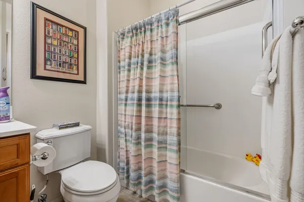 a white toilet sitting next to a bathroom sink and a shower
