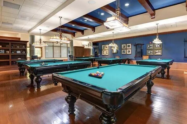 a room with pool table windows and wooden floor