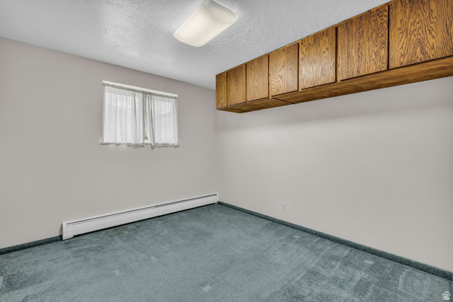 10705 Green Ridge Drive Sandy, UT 84070 - Photo 25 of 55 Carpeted spare room featuring a baseboard heating unit and a textured ceiling